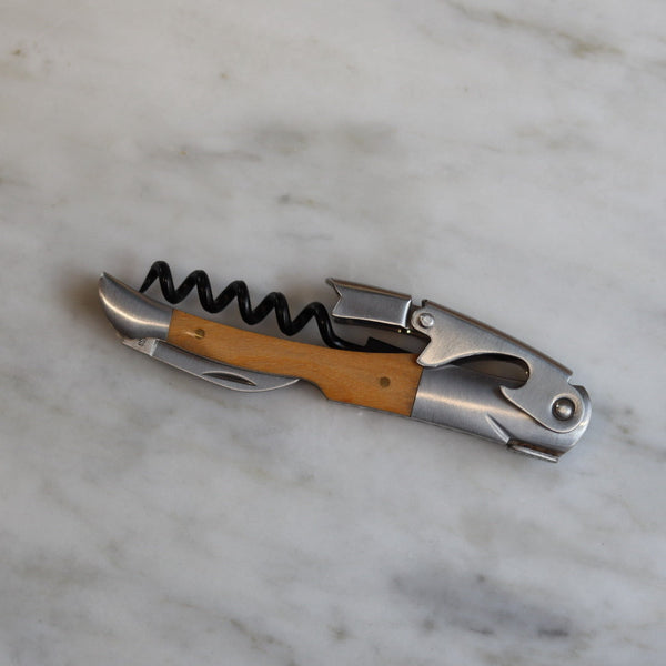 Corkscrew with wooden handle on a marble surface