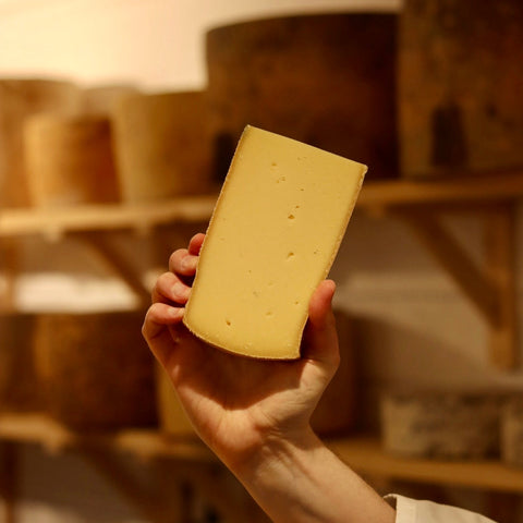 Hand-cut wedge of Alpen Cheddar, a British artisan cheese from Rennet & Rind.