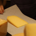 Hand wrapping Connage Gouda artisan cheese to order at Rennet & Rind.