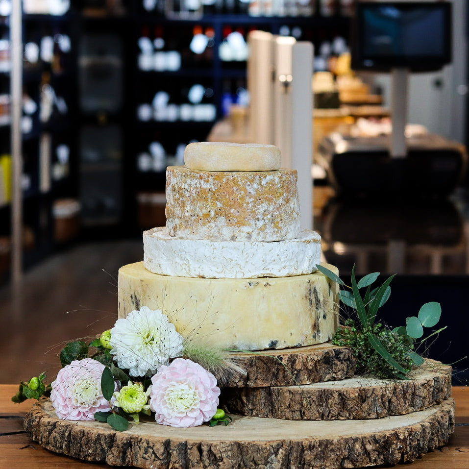 Newton cheese tower with four tiers of British artisan cheese on rustic board