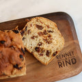 Moden's Lincolnshire Plum Bread sliced on a wooden board showing the fruit-packed crumb