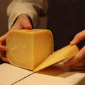 Cheesemonger cutting British Artisan Cheese Old Winchester to order at Rennet & Rind