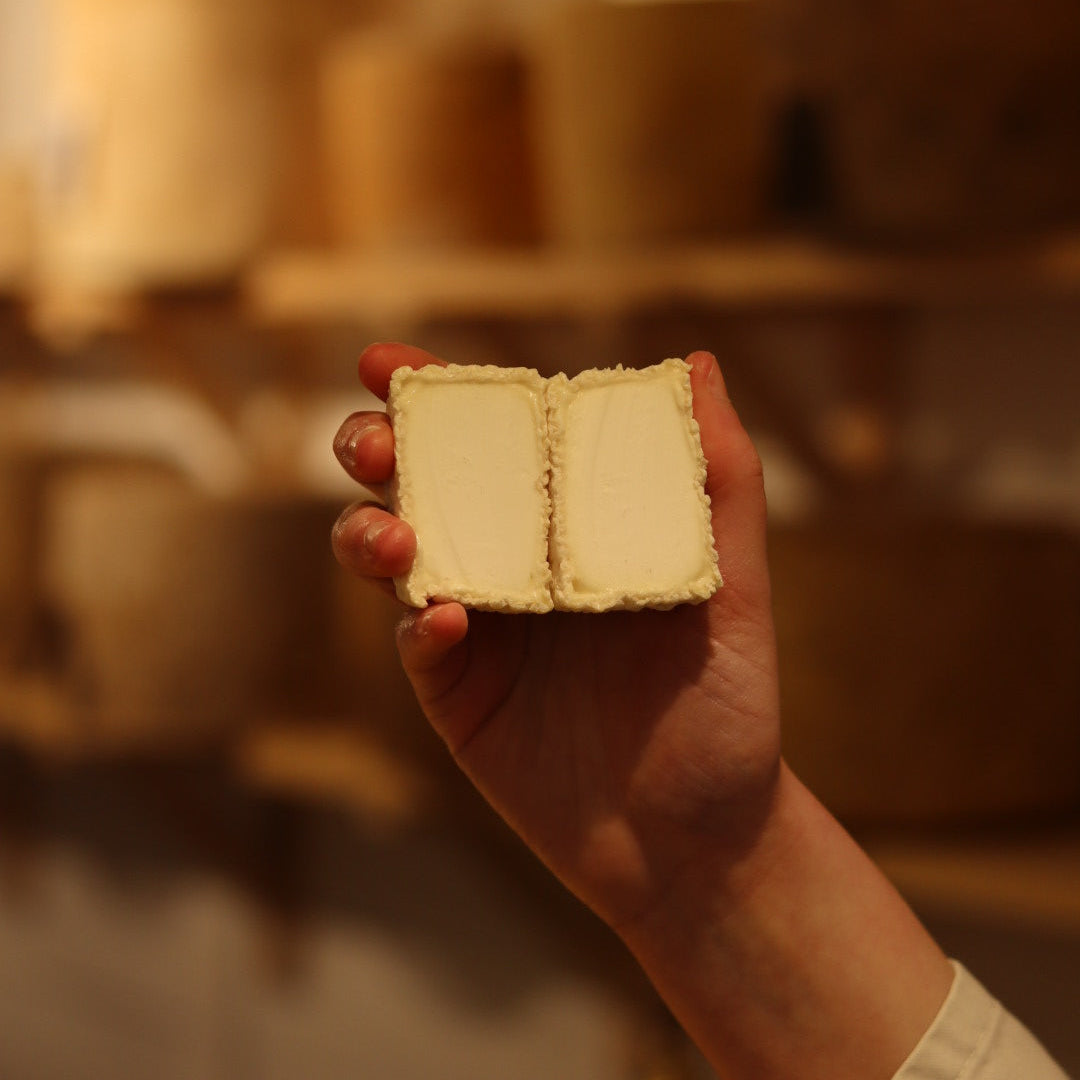 Rennet & Rind Cheesemonger holding freshly cut piece of British artisan goats cheese, Shilling 