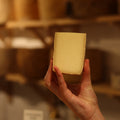 Cheesemonger holding piece of British artisan cheese, Spenwood at Rennet & Rind. 