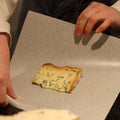 Cheesemonger wrapping a cut of British Artsian blue cheese, Stichelton for cutsomer at Rennet & Rind